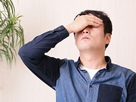 目元を抑える男性